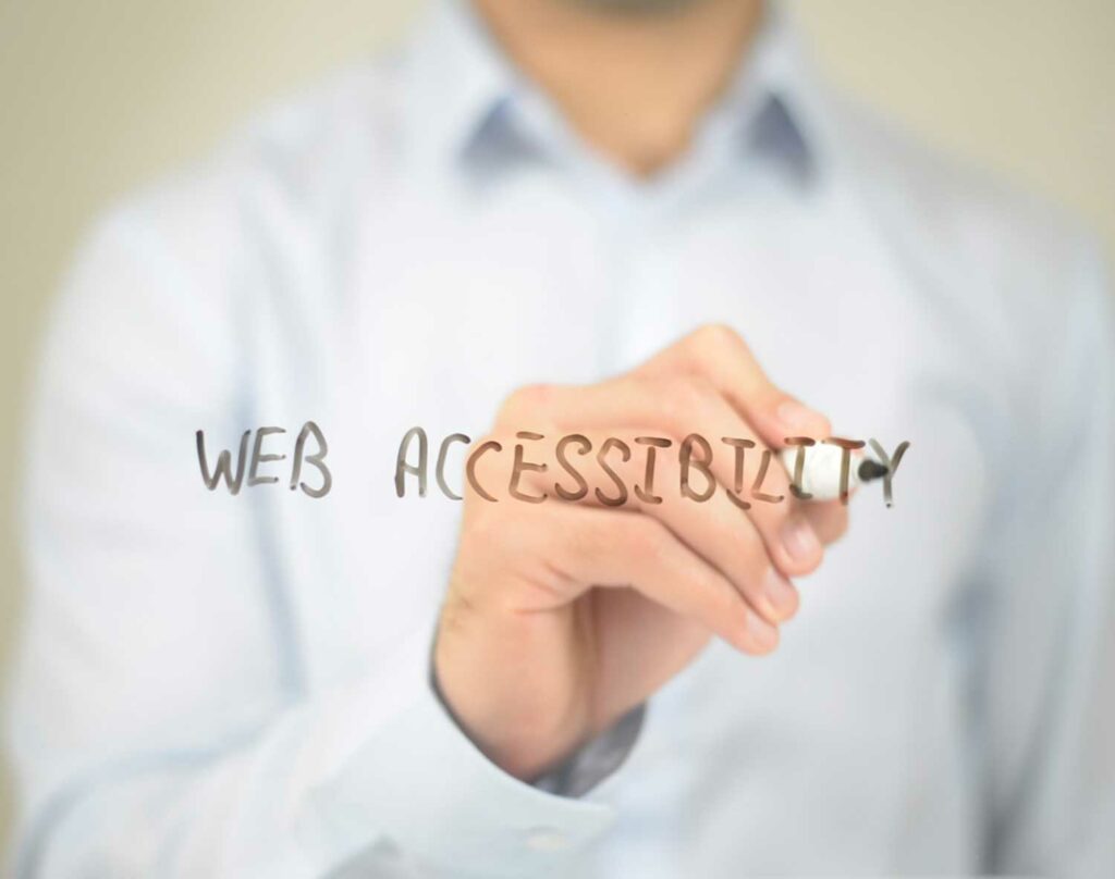 Man holds a sharpie writing about accessible web design.